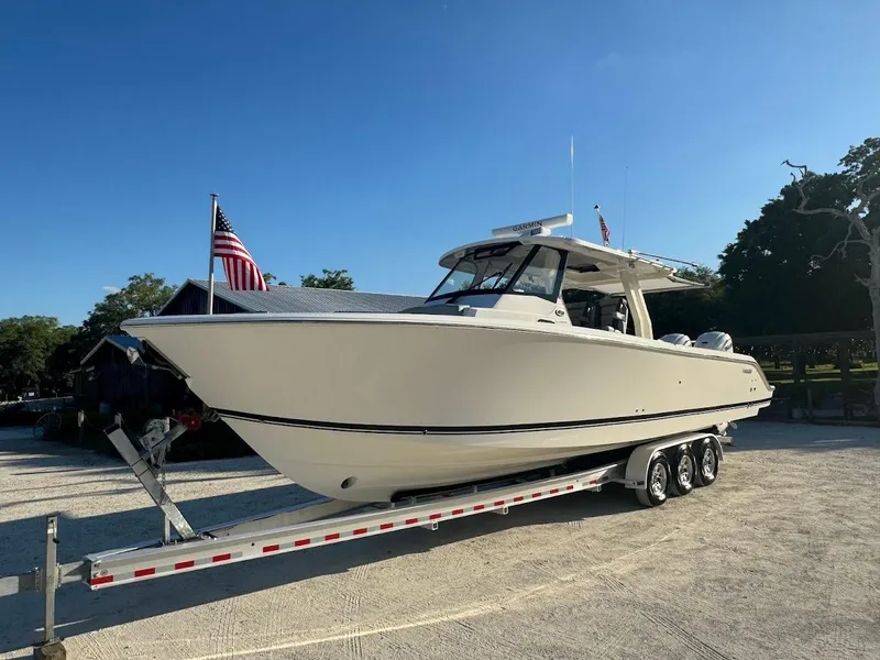 Slide: The Image of 2024 Pursuit S 358 Sport boat on trailer with American flag in background. - 19