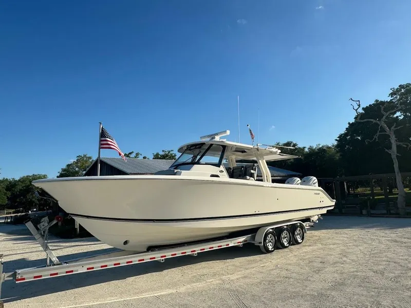Slide: The Image of 2024 Pursuit S 358 Sport boat on trailer, parked outdoors under clear blue sky. - 20