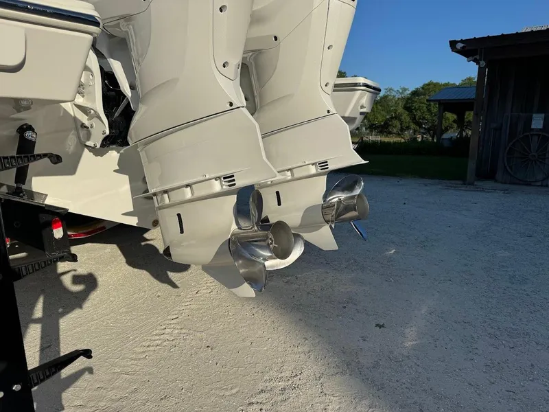 Slide: The Image of 2024 Pursuit S 358 Sport boat engines with dual propellers on a sunny day. - 32