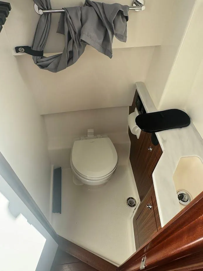 Slide: The Image of 2024 Pursuit S 358 Sport boat bathroom with toilet, sink, and storage cabinet. - 41
