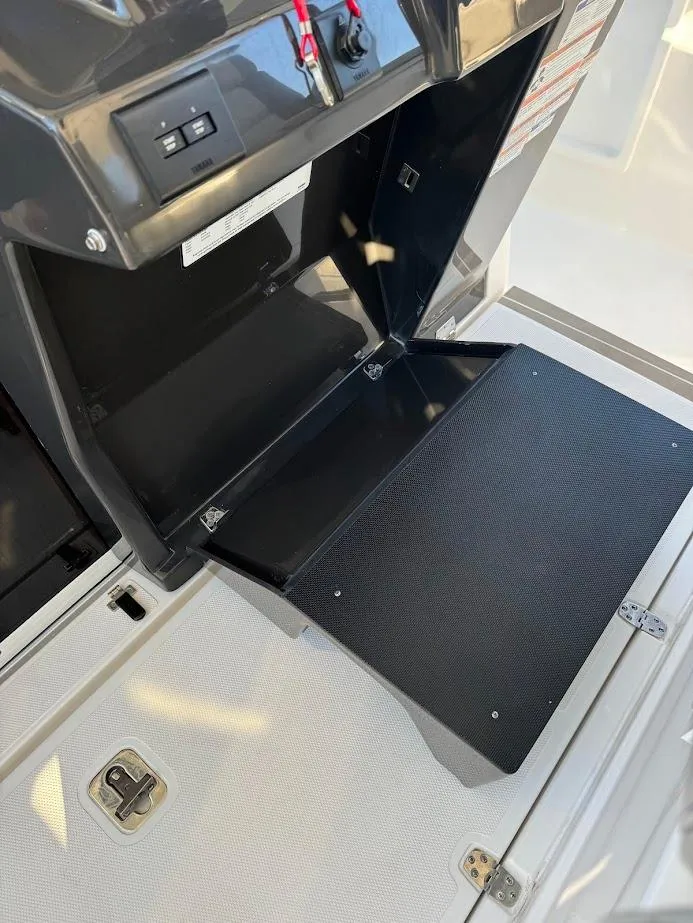 Slide: The Image of 2024 Pursuit S 358 Sport boat storage compartment with open hatch and textured flooring. - 44
