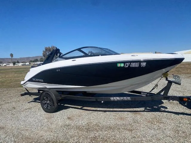 Slide: The Image of 2022 Scarab 195 ID boat on trailer, black and white design, parked outdoors. - 10