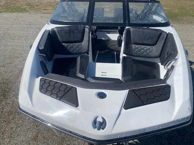 Slide: The Image of 2022 Scarab 195 ID boat with black seating and sleek design on a gravel surface. - 11