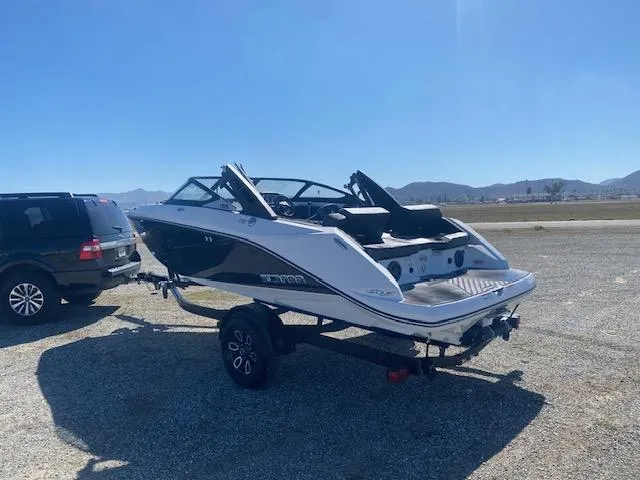 Slide: The Image of 2022 Scarab 195 ID boat on trailer, parked outdoors under clear blue sky. - 4