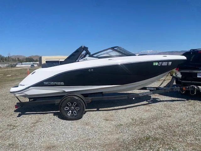 Slide: The Image of 2022 Scarab 195 ID boat on trailer, black and white design, parked outdoors. - 8