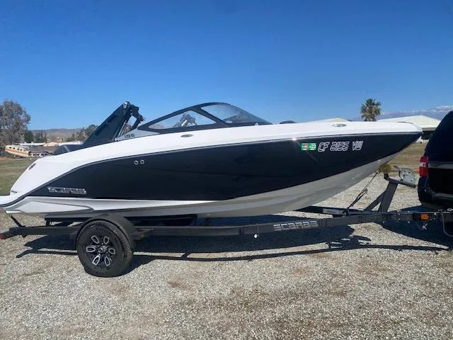 Slide: The Image of 2022 Scarab 195 ID boat on trailer, black and white design, parked outdoors. - 9