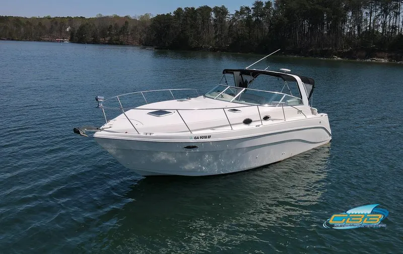 Slide: The Image of 2000 Rinker 340 Express Cruiser on calm lake with forested shoreline. - 10