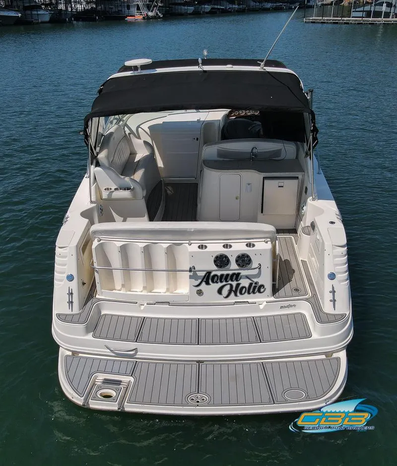 Slide: The Image of 2000 Rinker 340 Express Cruiser on water, rear view with black canopy. - 12