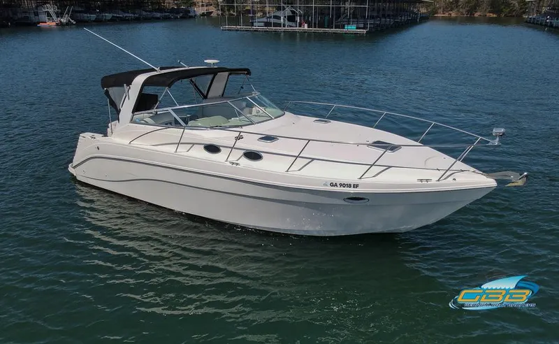 Slide: The Image of 2000 Rinker 340 Express Cruiser on calm water, featuring sleek design and spacious deck. - 2