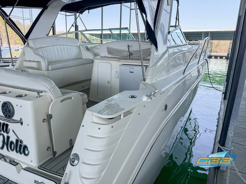 Slide: The Image of 2000 Rinker 340 Express Cruiser docked, showcasing spacious seating and sleek design. - 20