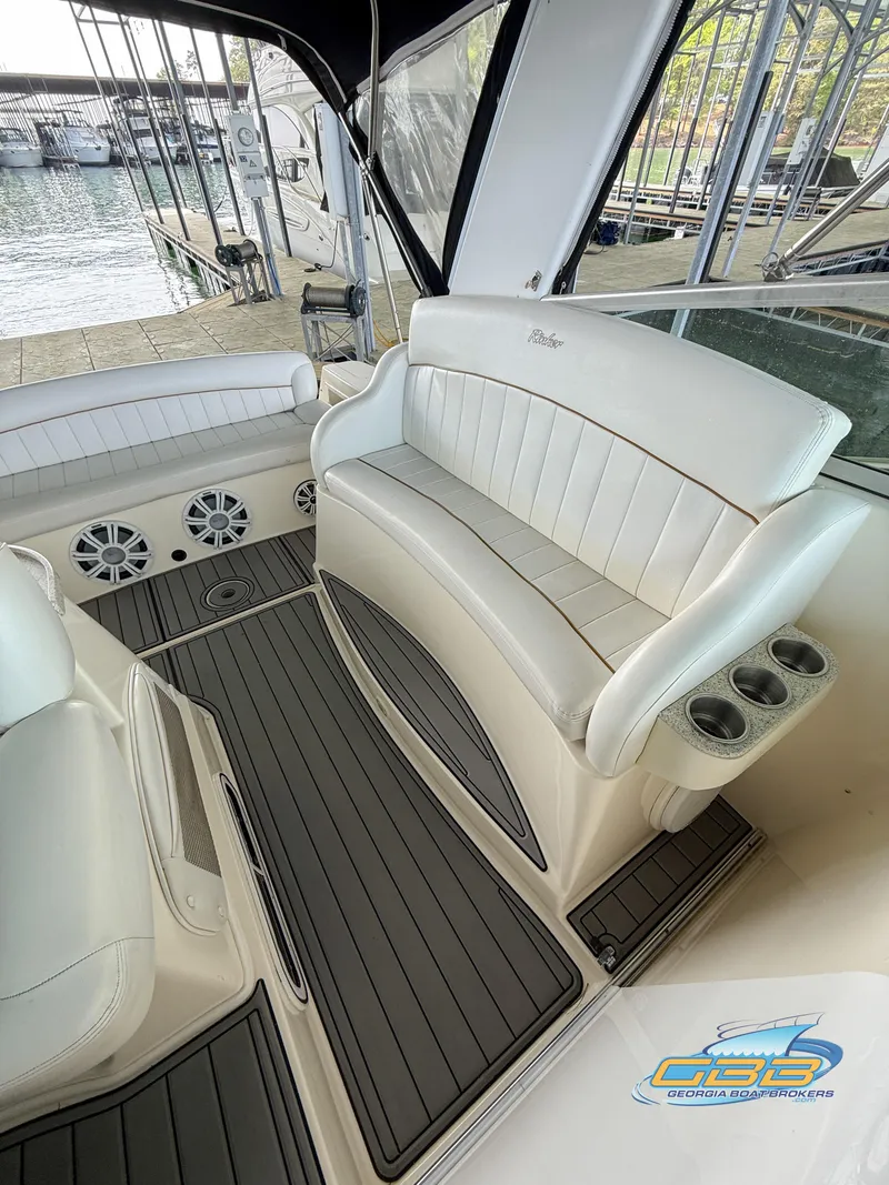 Slide: The Image of 2000 Rinker 340 Fiesta Vee boat interior with white seating and cup holders. - 26