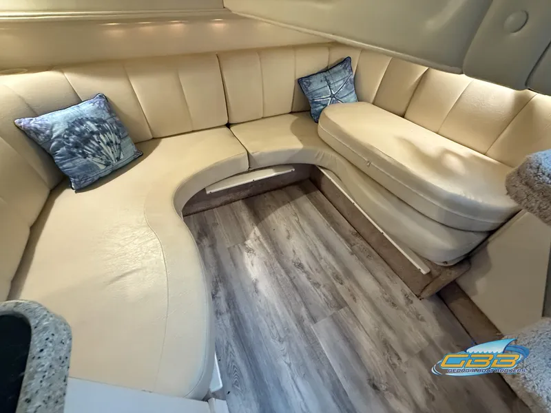 Slide: The Image of Interior of 2000 Rinker 340 Fiesta Vee with beige seating and decorative pillows. - 31