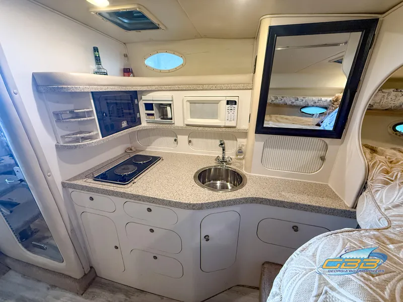 Slide: The Image of 2000 Rinker 340 Fiesta Vee yacht interior kitchen with stove, sink, and microwave. - 32