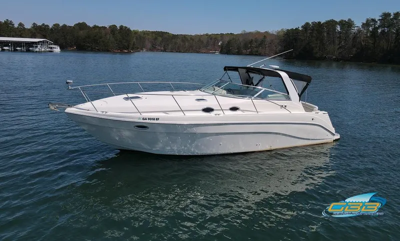 Slide: The Image of 2000 Rinker 340 Express Cruiser on a serene lake with forested shoreline. - 4