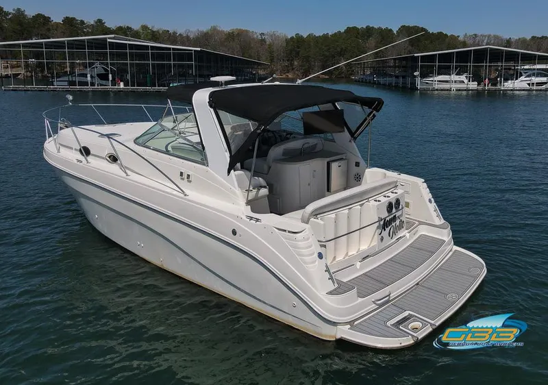 Slide: The Image of 2000 Rinker 340 Express Cruiser on water, rear view, with black canopy. - 5