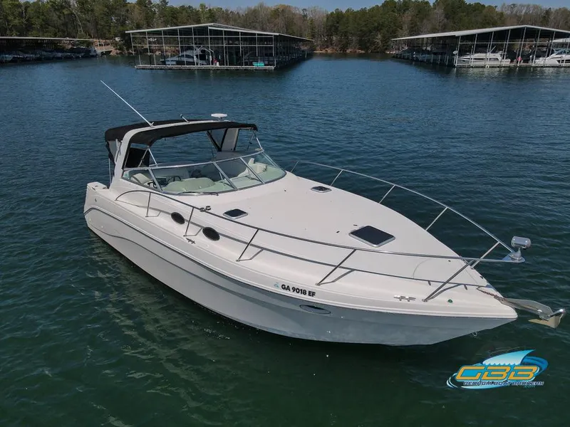 Slide: The Image of 2000 Rinker 340 Express Cruiser on calm lake near docks. - 8