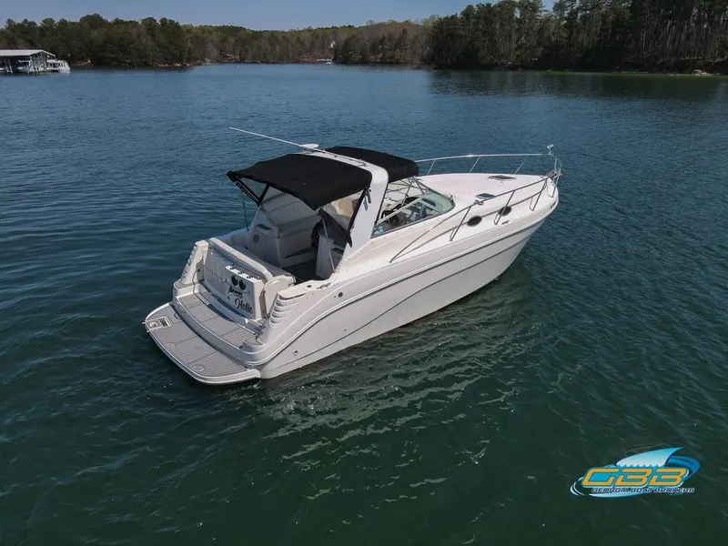 Slide: The Image of 2000 Rinker 340 Express Cruiser on serene lake with forested shoreline. - 9