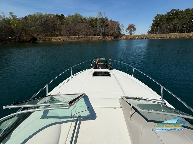 Slide: The Image of 2008 Monterey 250 Cruiser on serene lake with open deck and scenic forest backdrop. - 19