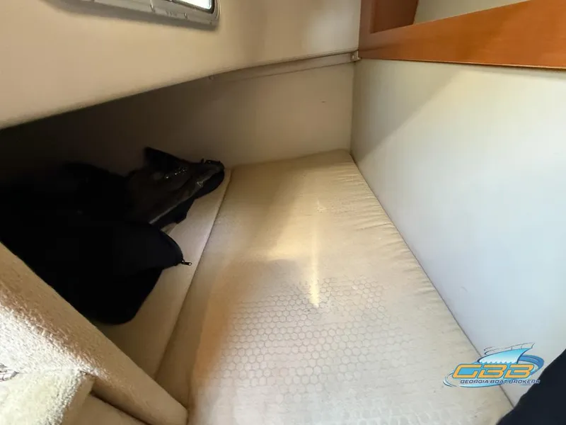 Slide: The Image of 2008 Monterey 250 Cruiser cabin interior with a cozy sleeping area and window. - 28