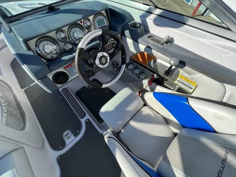 Slide: The Image of 2008 Nautique 210 boat interior with steering wheel, gauges, and blue-accented seating. - 18