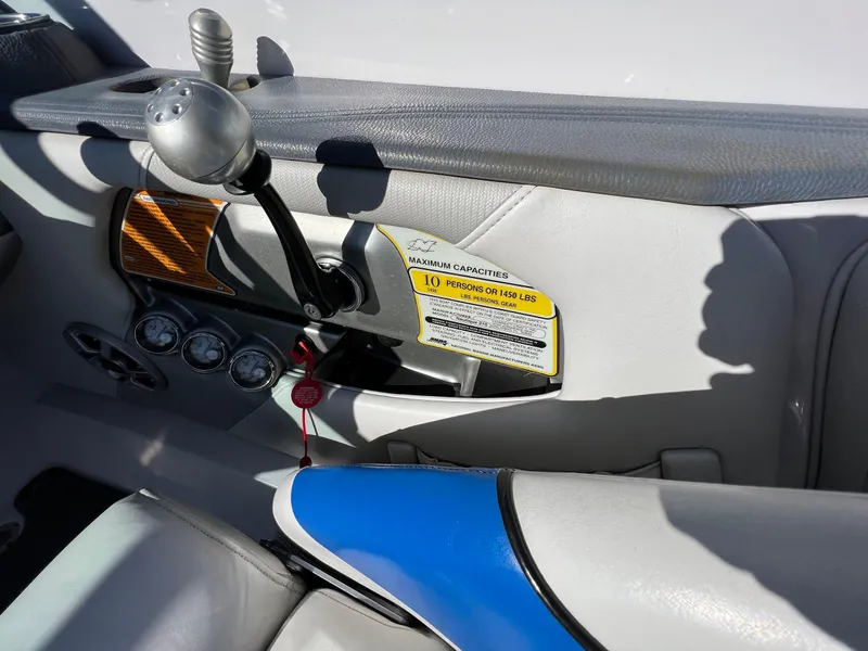 Slide: The Image of Interior of 2008 Nautique 210 boat showing controls and seating capacity label. - 19