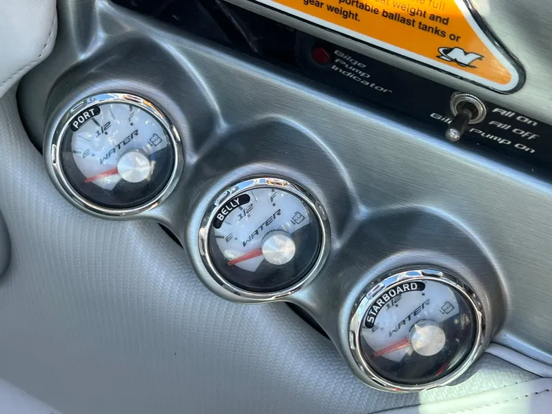 Slide: The Image of Gauges on a 2008 Nautique 210 boat dashboard showing port, belly, and starboard levels. - 36