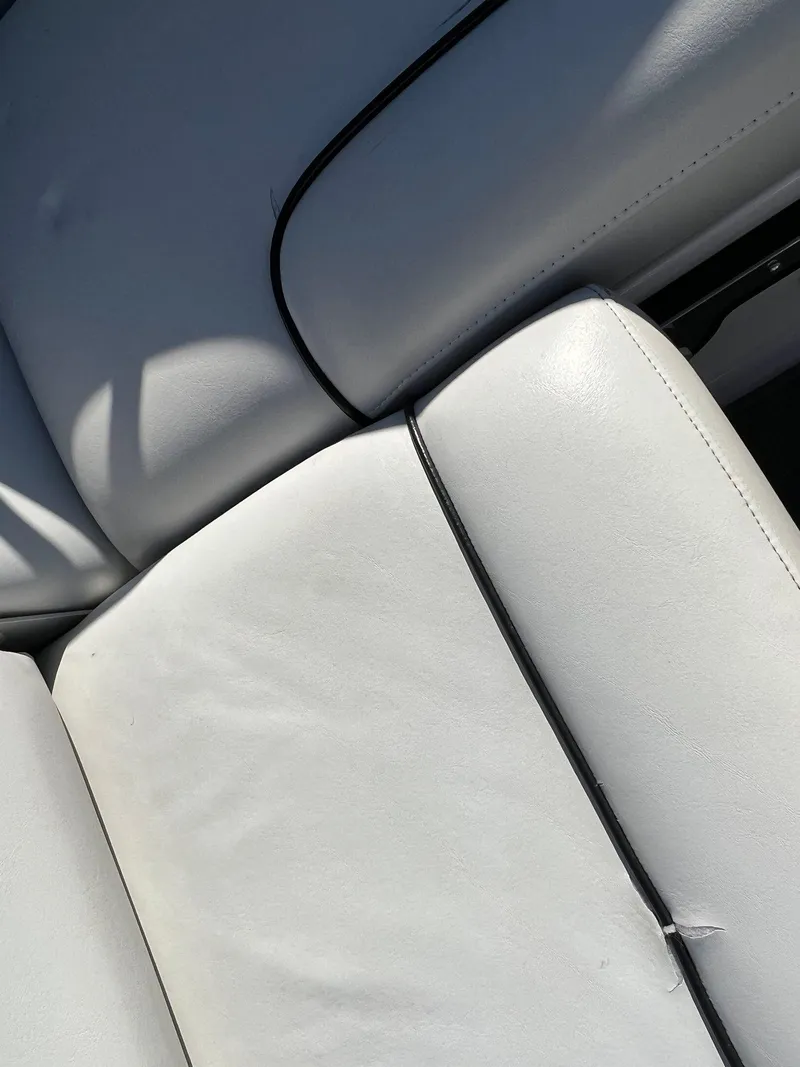 Slide: The Image of White leather seats of a 2008 Nautique 210 boat with black piping detail. - 37