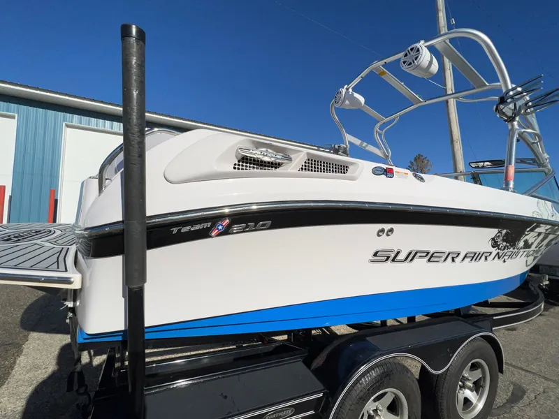 Slide: The Image of 2008 Nautique 210 boat on trailer, white and blue, with wakeboard tower. - 6