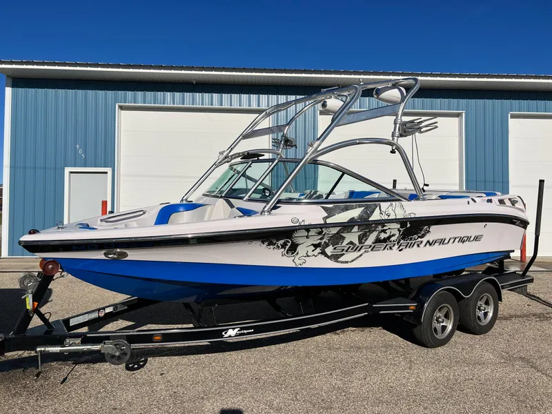 Slide: The Image of 2008 Nautique Super Air 210 boat on trailer, parked outside blue garage. - 10