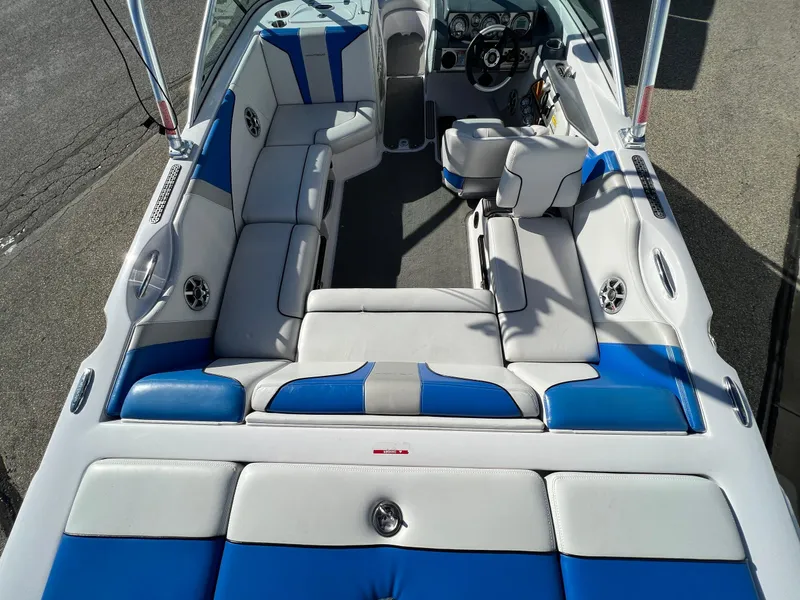 Slide: The Image of 2008 Nautique Super Air 210 boat interior with blue and white seating, steering wheel, and dashboard. - 15