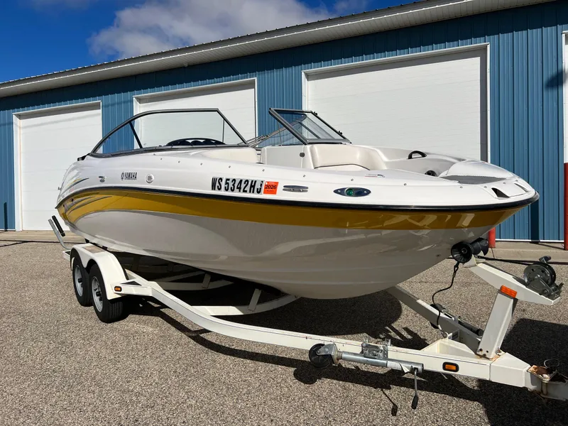 Slide: The Image of 2006 Yamaha Boats SR 210 on trailer, parked outside blue building. - 0