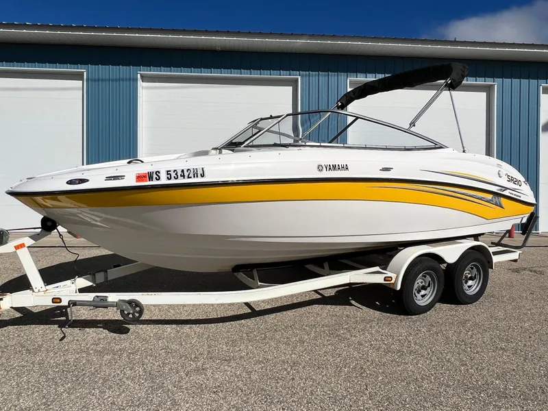 Slide: The Image of 2006 Yamaha Boats SR 210 on trailer, white with yellow stripe, parked outdoors. - 26