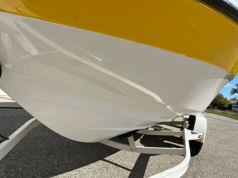 Slide: The Image of 2006 Yamaha Boats SR 210 on trailer, showcasing sleek yellow and white hull design. - 28