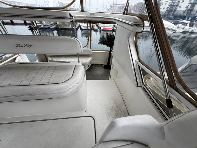 Slide: The Image of 1998 Sea Ray 370 Aft Cabin interior with marina view, featuring white seating and windows. - 17
