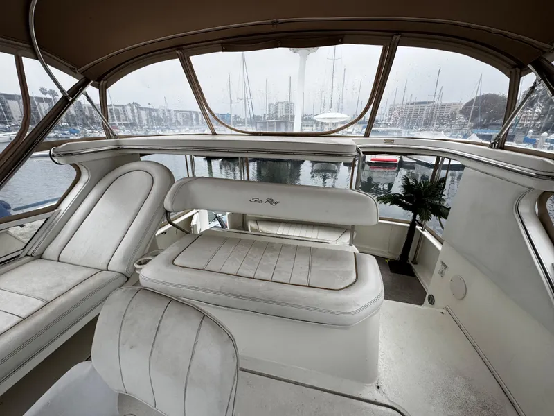 Slide: The Image of 1998 Sea Ray 370 Aft Cabin interior with marina view, featuring white seating and helm area. - 18