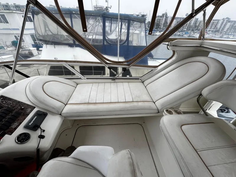 Slide: The Image of 1998 Sea Ray 370 Aft Cabin interior with white seating and marina view. - 20