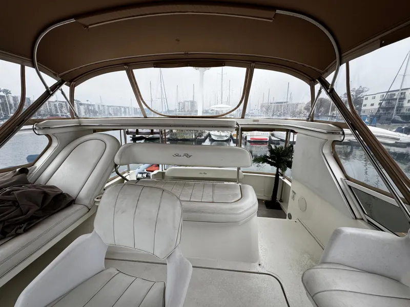 Slide: The Image of 1998 Sea Ray 370 Aft Cabin interior with white seating and marina view. - 22