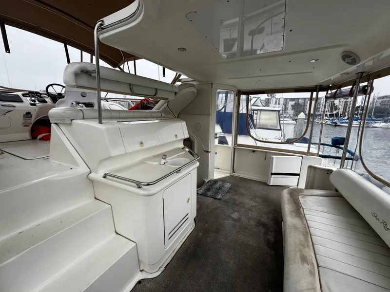 Slide: The Image of 1998 Sea Ray 370 Aft Cabin interior with seating, helm, and marina view. - 26