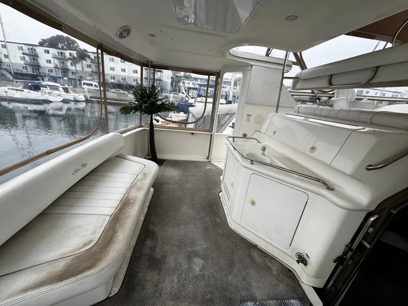 Slide: The Image of 1998 Sea Ray 370 Aft Cabin interior with white seating and marina view. - 30