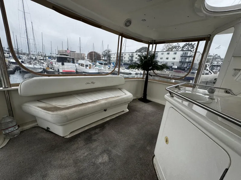 Slide: The Image of 1998 Sea Ray 370 Aft Cabin interior with marina view, featuring white seating and carpeted floor. - 31