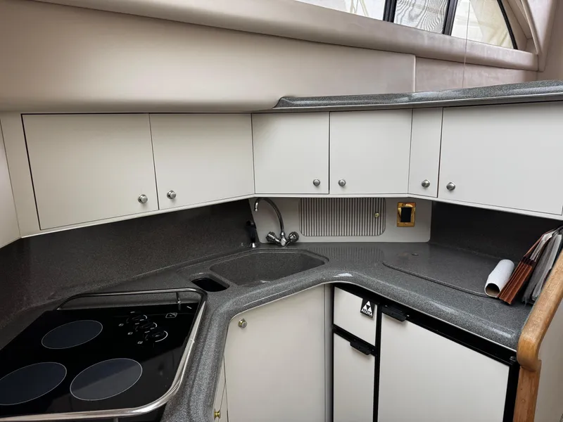Slide: The Image of 1998 Sea Ray 370 Aft Cabin kitchen with modern appliances and sleek cabinetry. - 39