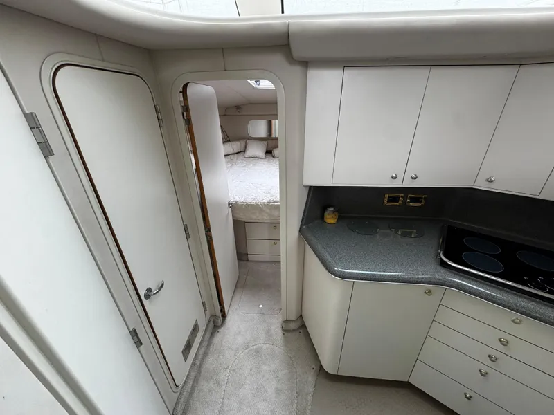 Slide: The Image of 1998 Sea Ray 370 Aft Cabin interior with kitchen and bedroom view. - 42