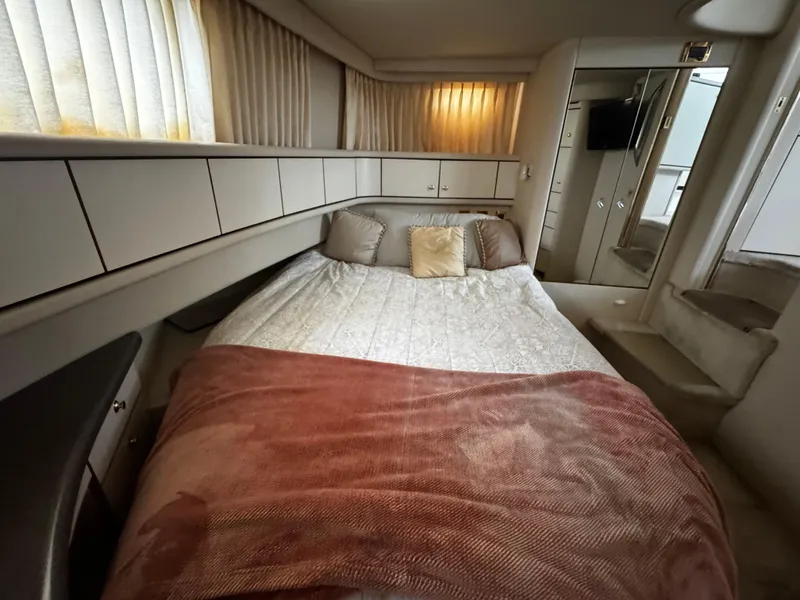 Slide: The Image of 1998 Sea Ray 370 Aft Cabin bedroom with cozy bed, pillows, and soft lighting. - 44