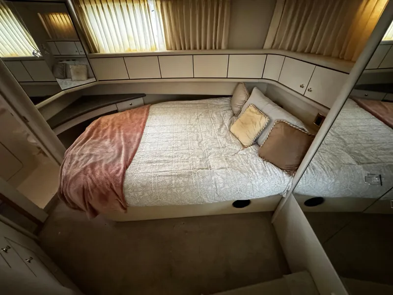 Slide: The Image of 1998 Sea Ray 370 Aft Cabin bedroom with cozy bed, pillows, and soft lighting. - 46