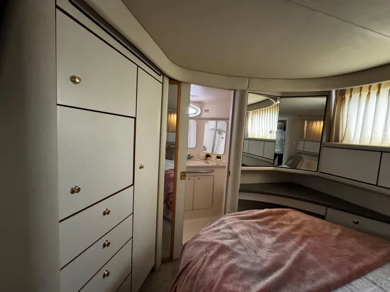 Slide: The Image of 1998 Sea Ray 370 Aft Cabin interior with bed, cabinets, and bathroom view. - 47