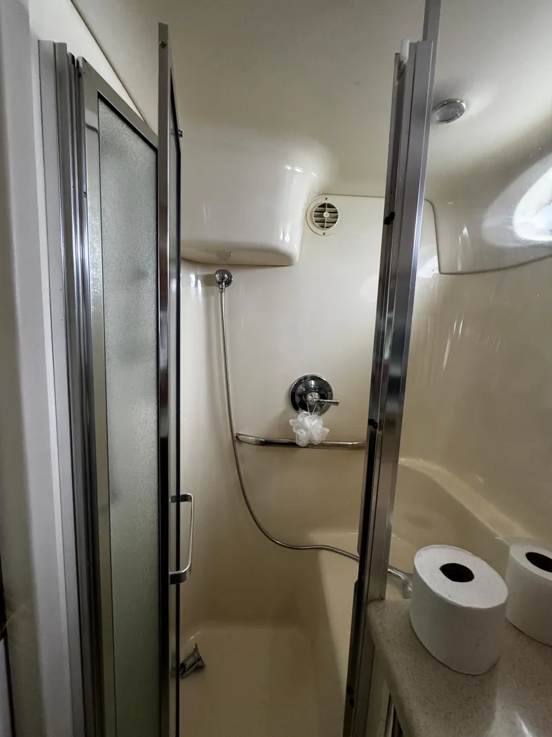Slide: The Image of 1998 Sea Ray 370 Aft Cabin bathroom with shower and toilet paper rolls. - 48
