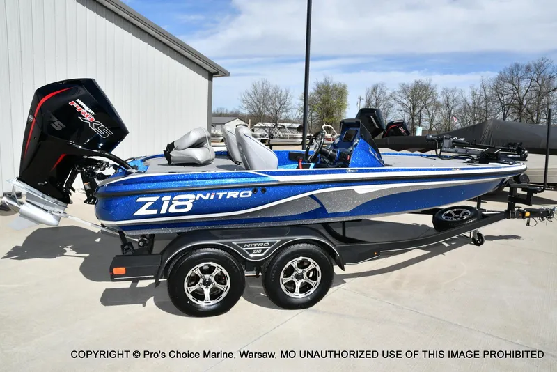 Slide: The Image of 2023 Nitro Z18 Pro boat with 175 Pro-XS engine, blue and white design, on trailer. - 21