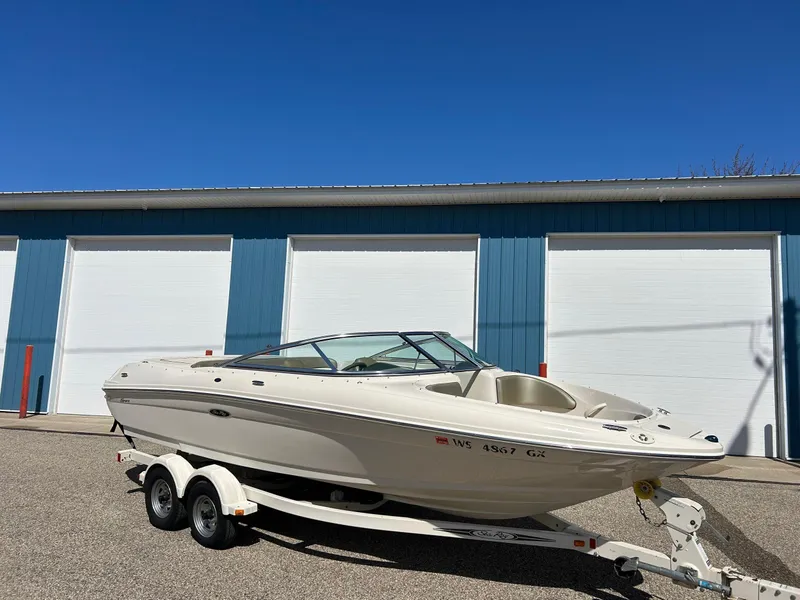 Slide: The Image of 2005 Sea Ray 200SP boat on trailer, parked outside blue storage units. - 1