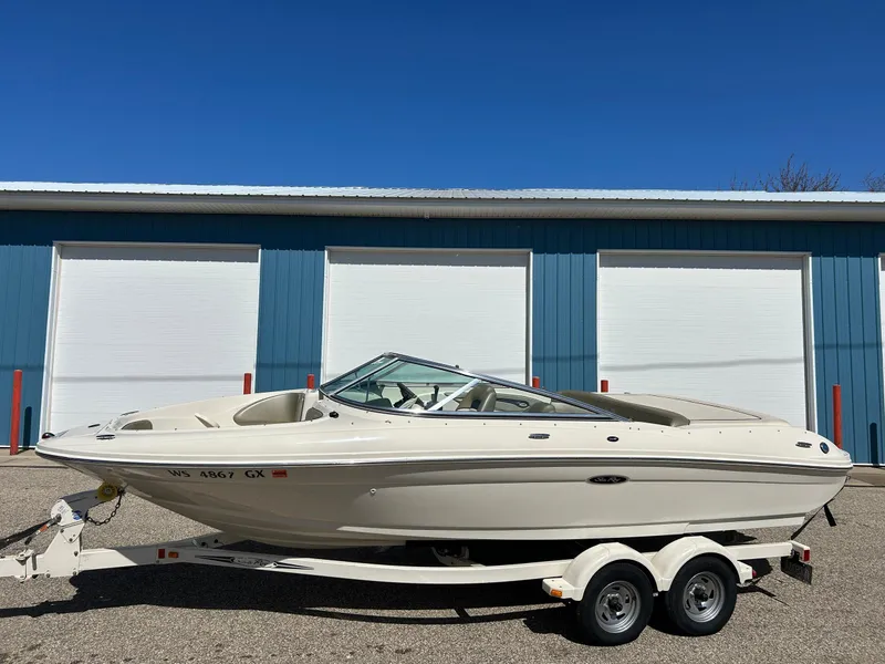 Slide: The Image of 2005 Sea Ray 200SP boat on trailer, parked in front of blue storage units. - 10