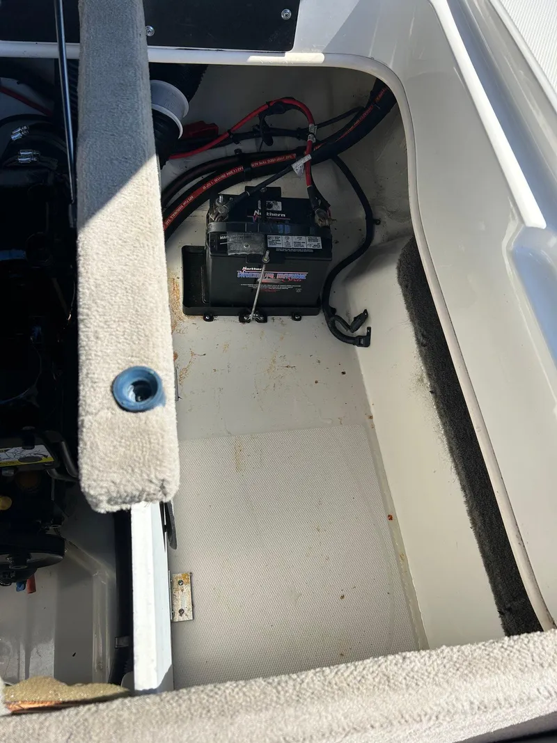 Slide: The Image of Battery compartment of a 2005 Sea Ray 200SP boat, showing wiring and storage area. - 17